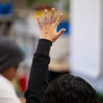 1st Grader raises hand to ask a question during class