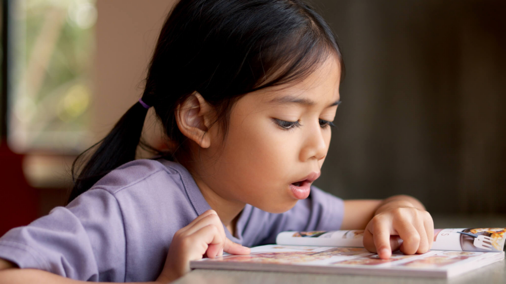 child wearing headphones works with virtual tutor on a laptop