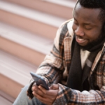 Man wearing headphones looking at his phone