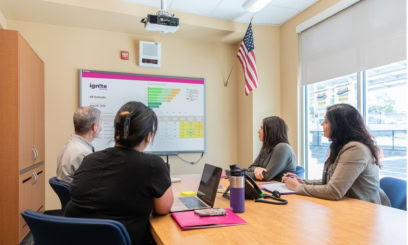 school staff look at student progress monitoring data on a whiteboard