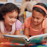 Two girls reading a book in a classroom