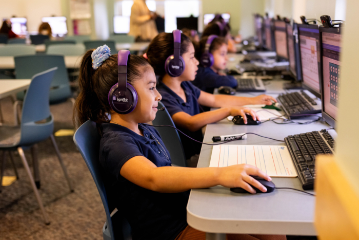 an elementary classroom shows tutoring for students going on with students on laptops with online tutors