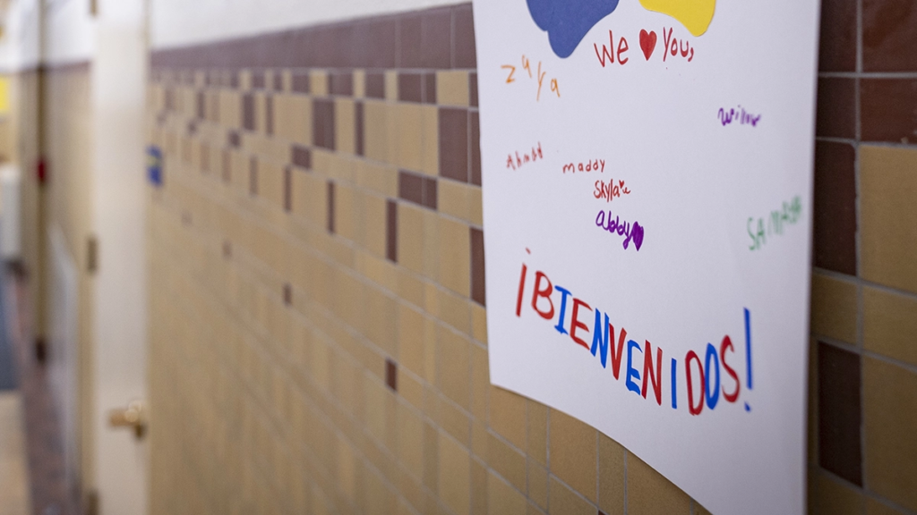 Sign on school wall says Bienvenidos, welcoming English language learners to school in Spanish