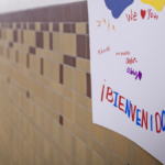 Sign on school wall says Bienvenidos, welcoming English language learners to school in Spanish