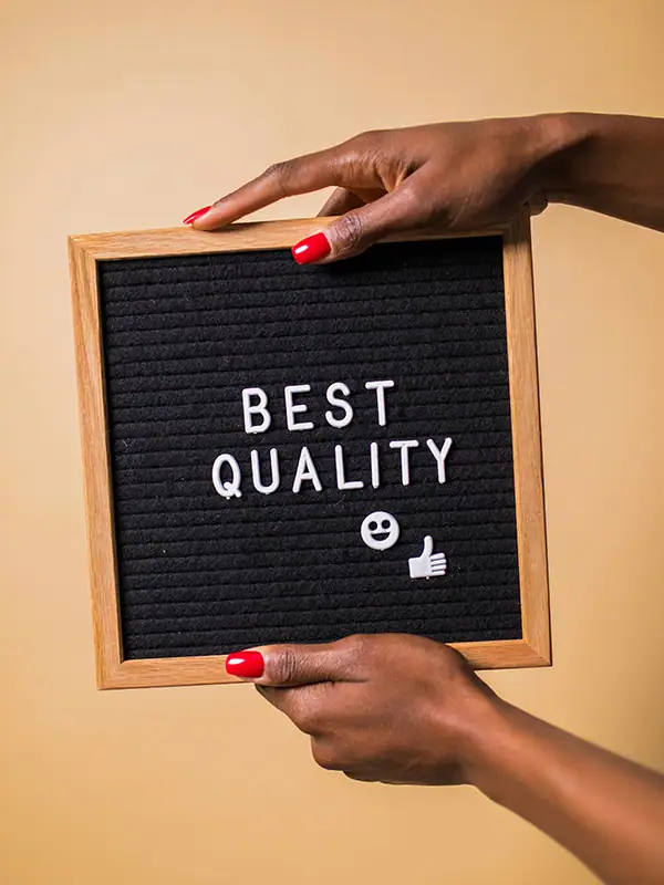 hands holding a message board with the words best quality