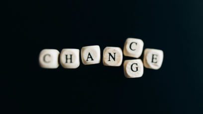 Scrabble tiles spell out the words chance and change on a black background
