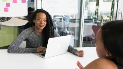 Literacy Coach with laptop in front of her talking to teacher