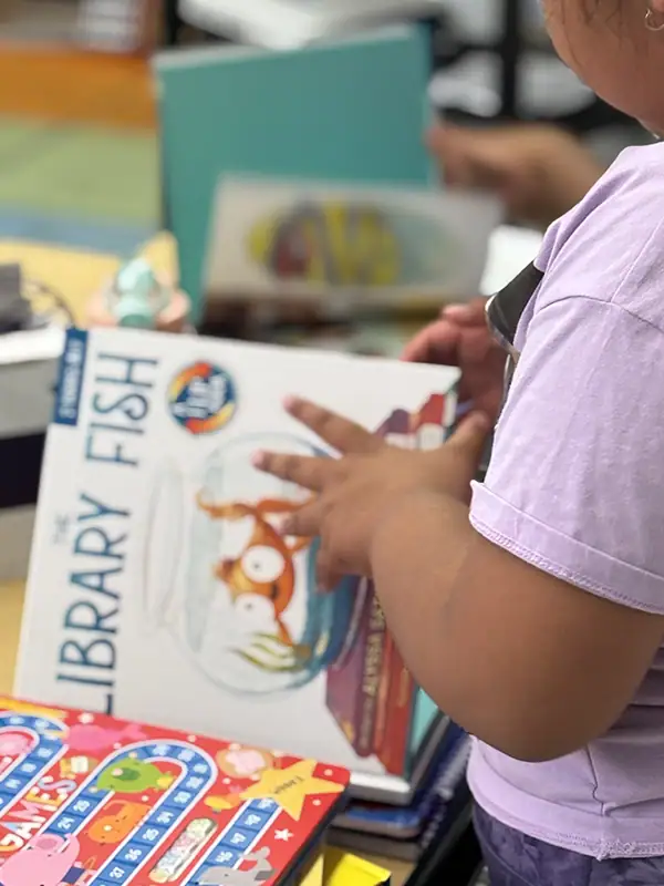 ROI of Reading Interventions — Proving Impact in Student Outcomes & District Budgets 5 1st grade Student Reading a book called Library Fish
