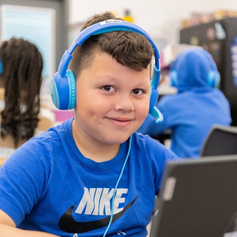 a male Student With Headphones Tutoring At Laptop