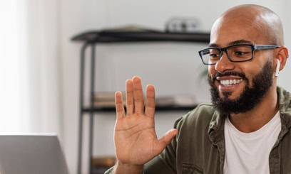 A male reading tutor raises his hand while working virtually with a student